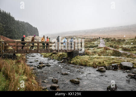 Wanderer über eine Fußgängerbrücke mit dem Pen Y Fan, der höchste Gipfel in South Wales in die Brecon Beacons steigen die Temperaturen über Großbritannien erwartet werden an diesem Wochenende mit dem Wetter Warnungen für Eis ausgegeben abzusinken. Stockfoto