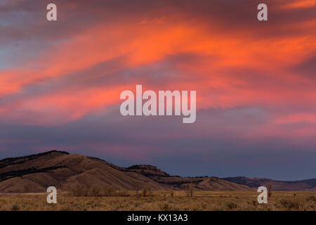 Den feurigen Sonnenuntergang beleuchtet die Himmel über Blacktail Butte und Jackson Hole. Der Grand Teton National Park, Wyoming Stockfoto