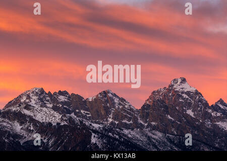 Eine glühende Sonnenuntergang beleuchtet die Gipfel der großen, mittleren und südlichen Teton. Der Grand Teton National Park, Wyoming Stockfoto