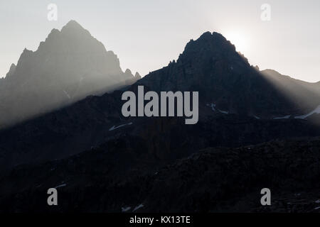 Die Sonne hinter der Mitte Teton steigende, Casting starke Lichtstrahlen oberhalb der South Fork von Cascade Canyon. Der Grand Teton National Park, Wyoming Stockfoto