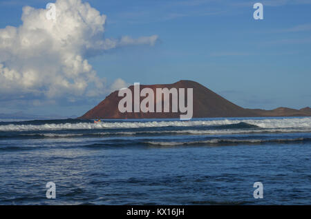 Caldera Berg auf der Insel Los Lobos vom Strand von den Dünen von Fuerteventura, Kanarische Inseln gesehen Stockfoto