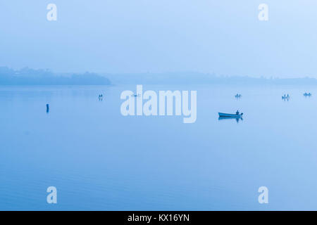 Angeln am Morgen Nebel auf dem See im Draycote Waters, Vereinigtes Königreich Stockfoto