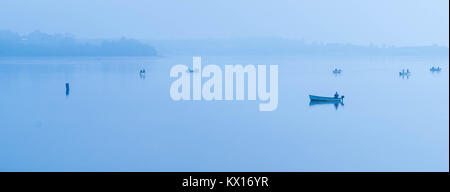 Angeln am Morgen Nebel auf dem See im Draycote Waters, Vereinigtes Königreich Stockfoto
