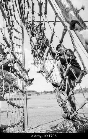 Britische Armee squaddies in der Grundausbildung klettern über Seil Verrechnung als Teil eines Hindernisparcours, 15. Juni 1993 Stockfoto