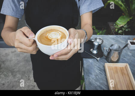 Hände halten Tasse heißen Kaffee Latte Cappuccino Stockfoto
