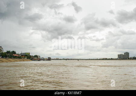 Über den Tonle Sap Fluss mit dem Boot in Phnom Penh, Kambodscha, mit bewölkt regen Himmel während der Monsunzeit, Japan Kambodscha Friendship Bridge in der Entfernung Stockfoto