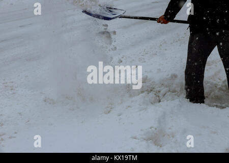Mann Reinigung Schnee von einem Laufsteg mit Kopie Raum Mann Entfernen von Schnee mit einer Schaufel Stockfoto