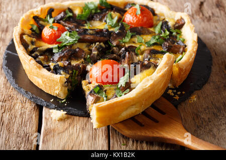 In Scheiben geschnittene Pilze Tarte mit Käse und Tomaten close-up auf dem Tisch. Horizontale Stockfoto