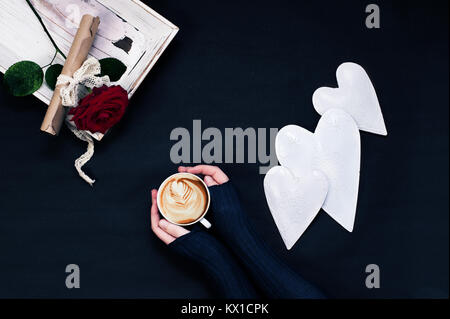 Ansicht von oben morgen Komposition mit Valentinstag schreiben, rote Rose, Tasse Cappuccino in weiblichen Händen und weiß Herz formen Stockfoto