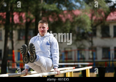 Belarus, Gomel, 21. April 2017. Öffnen Lektion auf die Brandbekämpfung. Übungen auf der Quertraverse. Physikalische Kultur Lektion. Eine junge TURNERIN. Die sportliche Ausbildung von so Stockfoto