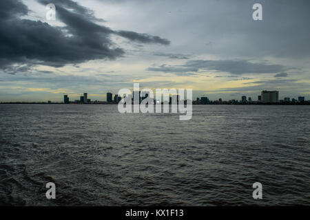 Phnom Penh Dämmerung Sonnenuntergang, wie vom Mekong und Tonle Sap Fluss gesehen, und die aufstrebenden Wolkenkratzer. Monsunzeit und Regen Wolken der Stadt Stockfoto