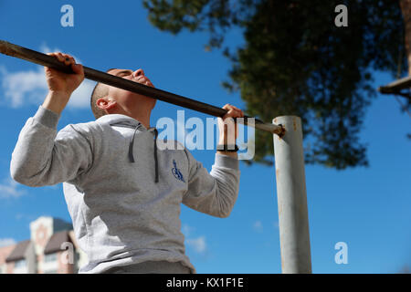 Belarus, Gomel, 21. April 2017. Öffnen Lektion auf die Brandbekämpfung. Übungen auf der Quertraverse. Physikalische Kultur Lektion. Eine junge TURNERIN. Die sportliche Ausbildung von so Stockfoto