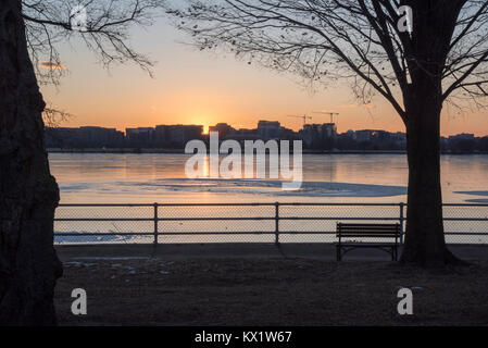 Washington DC, USA. 06 Jan, 2018. Den Potomac River am Hains Punkt im East Potomac Park, Washington DC spiegelt die untergehende Sonne auf dem teilweise gefrorenen Oberfläche. Crystal City können im Profil über das Wasser gesehen werden. Credit: Angela Drake/Alamy leben Nachrichten Stockfoto