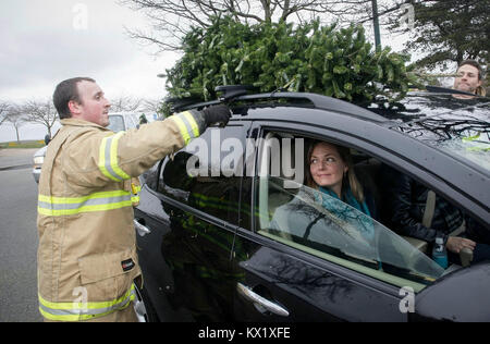 Richmond, Kanada. 6. Januar, 2018. Ein Feuerwehrmann entfernt ein Baum von einem Auto während der jährlichen Weihnachtsbaum chipping Veranstaltung in Richmond, Kanada, Jan. 6, 2018. Gesammelten Bäume werden abgebrochen und für Sie zu Ressourcen zugeführt werden. Credit: Liang Sen/Xinhua/Alamy leben Nachrichten Stockfoto