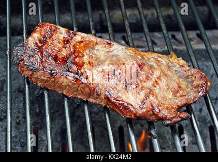 Steak kochen über Flammen auf dem Grill Stockfoto