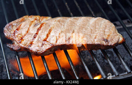 Steak kochen über Flammen auf dem Grill Stockfoto