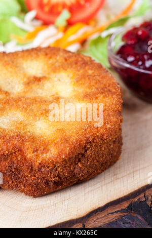 Panierter Camembert mit Salat auf Holz Stockfoto