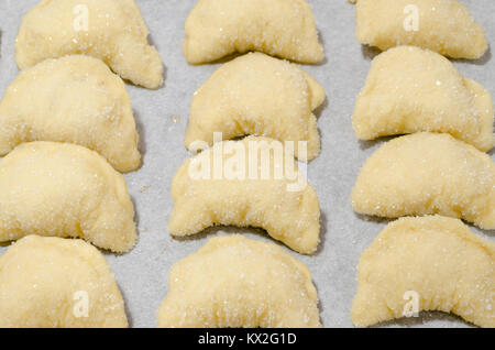 Satz von hausgemachten süßen Hefe Croissants während der Vorbereitung, fertig zu backen. Stockfoto