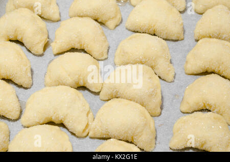 Satz von hausgemachten süßen Hefe Croissants während der Vorbereitung, fertig zu backen. Stockfoto