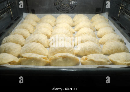 Satz von hausgemachten süßen Hefe Croissants in Zucker Kristalle abgedeckt und mit Äpfeln gefüllt, während des Backens inside home Bäckerei Backofen. Stockfoto