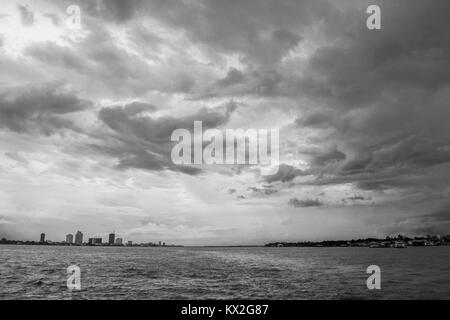 Wo der Mekong und Tonle Sap Fluss Banken in Phnom Penh Kambodscha, Südostasien, braunen Flusswasser, grau dicke Wolkendecke der Monsunzeit. Stockfoto