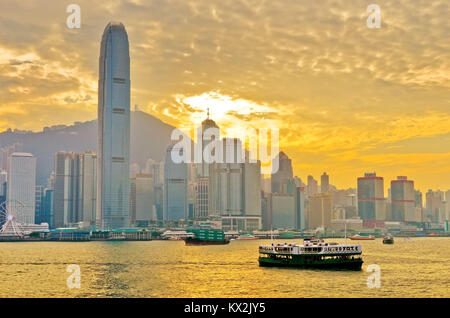 Hong Kong, China - 31. Dezember 2016: Hong Kong Skyline und Victoria Hafen mit Fähren auf der Durchreise bei Sonnenuntergang am 31. Dezember 2016. Stockfoto