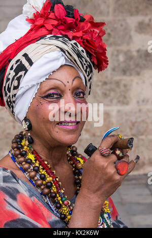 Porträt einer alten Frau in Anzug und typischen Verzierungen und Zigarre, in der Plaza de la Catedral de La Habana, Kuba Stockfoto
