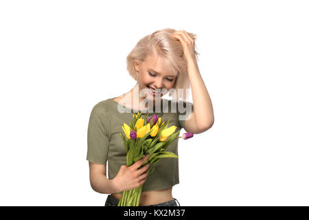 Schöne begeistert lächelnde Frau mit einem Blumenstrauß aus Tulpen auf weißem Hintergrund Stockfoto