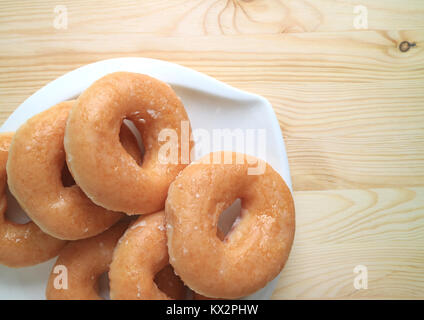 Ansicht von oben mit Zucker glasierte Donuts auf der weißen Teller am Tisch serviert Stockfoto