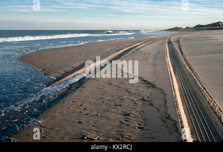 Strand: Abend Schatten und einen eingehenden Flut füllen die Tracks von einem Off-Road-Fahrzeug entlang der Kante von Cape Hatteras National Seashore. Stockfoto