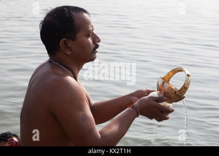 Ein männlicher Pilger betet neben dem Fluss Ganges in Varanasi, Indien Stockfoto