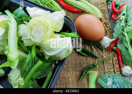 Gemischtes Gemüse und Ei auf dem hölzernen Tisch. Stockfoto