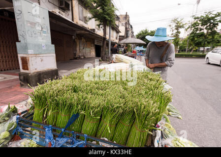 Ein Bangkok street Hersteller Verkauf von grünem Spargel Bündel von einer Karre in einer Stadt Straße von Bangkok, Thailand. Stockfoto