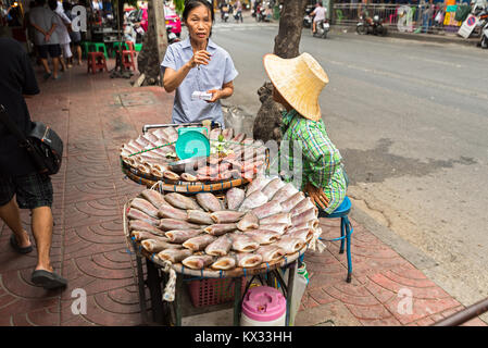 Einen getrockneten Fisch Straßenhändler verkaufen hier getrockneten und geräucherten Fisch aus Ihren Wagen auf einem Bangkok street Pflaster. Stockfoto