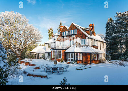 Prime Wohneigentum: Große freistehende Tarrant Haus und Garten, Surrey, England, mit einer dicken Schneedecke nach starkem Schneefall im Winter Stockfoto