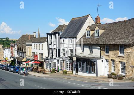 Anzeigen von Läden und Geschäften entlang der Hügel Einkaufsstraße während der Sommerzeit, Burford, Cotswolds, Oxfordshire, England, UK, Westeuropa. Stockfoto