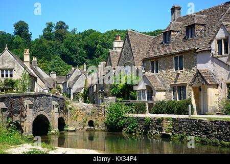 Steinbrücke über den Fluss Bybrook mit Hütten auf der Rückseite Castle Combe, Wiltshire, England, Vereinigtes Königreich, West-Europa. Stockfoto