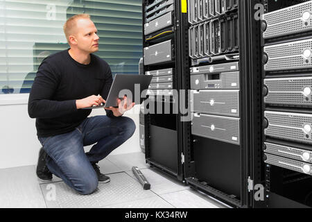 Berater mit Laptop während der Überwachung von Servern im Rechenzentrum Stockfoto
