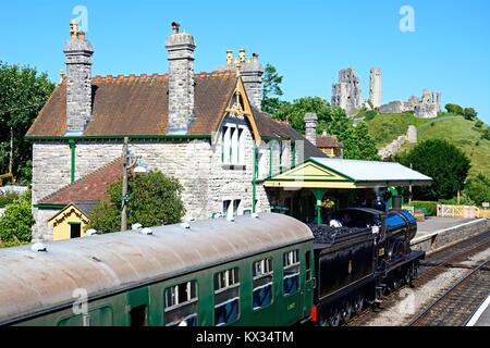 L &amp; SWR T9 Klasse 4-4-0-Dampfzug betreten des Bahnhofs mit dem Schloss auf der Rückseite, Corfe, Dorset, England, Vereinigtes Königreich, West-Europa. Stockfoto