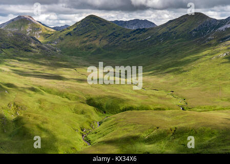 Die Aussicht auf ein grünes Tal in Irland Connemara National Park mit den Twelve Bens Berge im Hintergrund Stockfoto