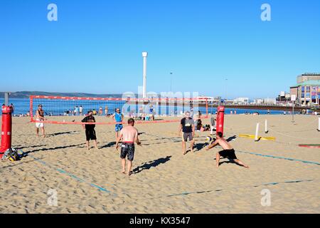 Eine Gruppe von Männern spielen Volleyball am Strand, Dorchester, Dorset, England, UK, Westeuropa. Stockfoto