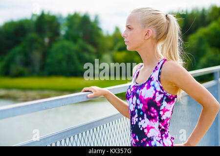 Nachdenkliche junge Frau ruht nach dem training Stockfoto