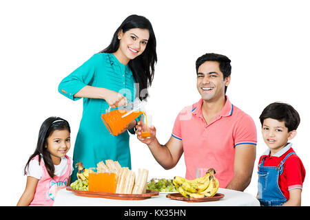 Familie mit Kindern Mutter mit Saft am Morgen Frühstück Stockfoto