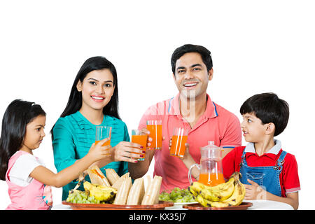Glückliche Familie, Eltern und Kinder zusammen Saft trinken Frühstücken Stockfoto