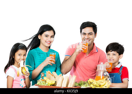Glückliche Familie, Eltern und Kinder trinken Orangensaft Frühstück Stockfoto