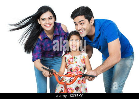 Glückliche Mutter und Vater Lehre Tochter zu Reiten Spaß genießen. Stockfoto