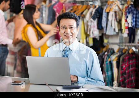 1 Business Manager mit Laptop arbeiten In Boutique speichern Stockfoto