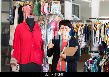 1 Weibliche Boutique maßgeschneiderte Fashion-Designer Holding Zwischenablage Arbeiten in Clothe-Shop Stockfoto