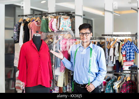 1 Weibliche Boutique Maßgeschneiderte angezeigt Thumbs-up mit Dummy-Dress in Clothe-Shop Stockfoto