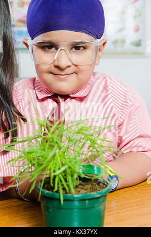 Indian School Kid junge Student Lupe prüfen Anlage Umwelt - Besorgnis Stockfoto